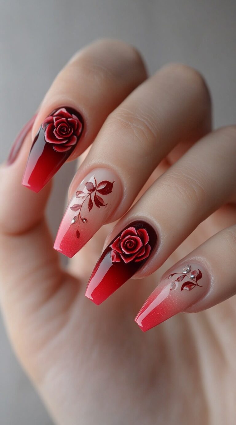 A set of coffin-shaped red ombre acrylic nails featuring 3D rose designs and floral detailing.