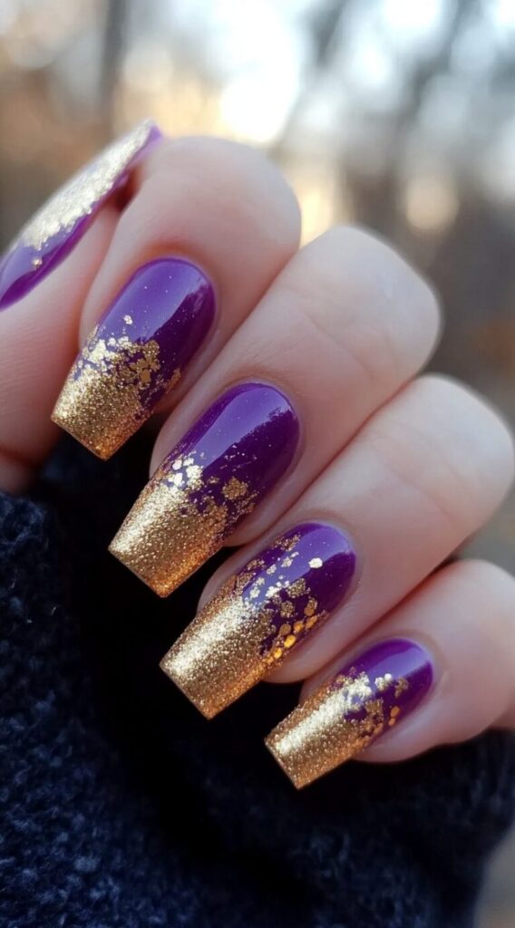 Close-up of long square nails painted in a glossy purple base with gold glitter gradient tips.