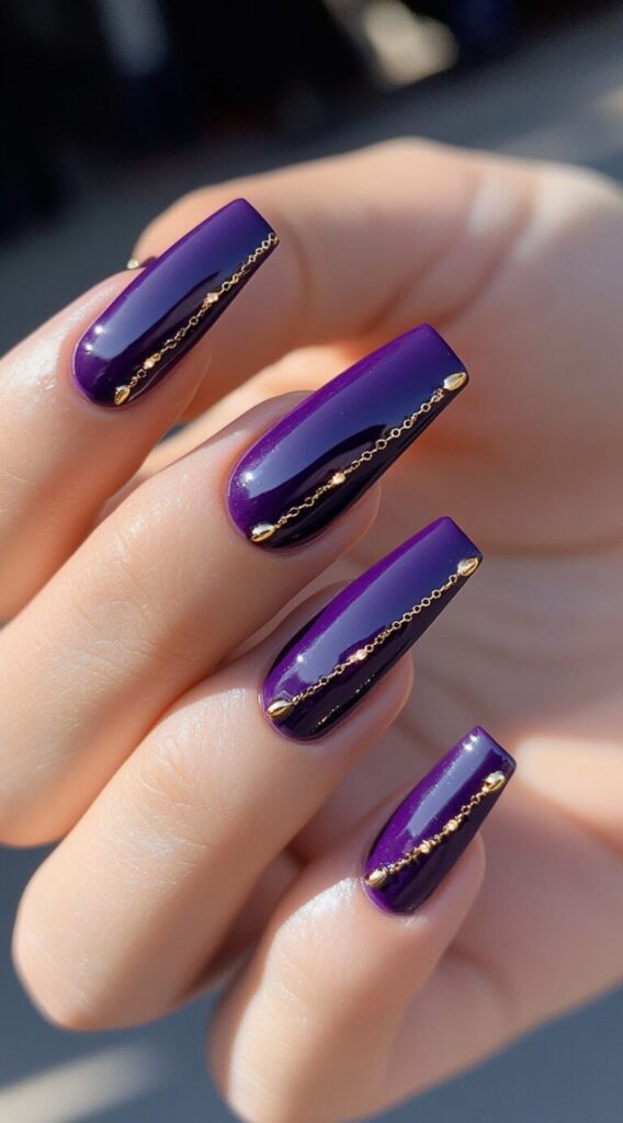 Glossy long square nails painted in rich purple, each adorned with a delicate gold chain down the center.