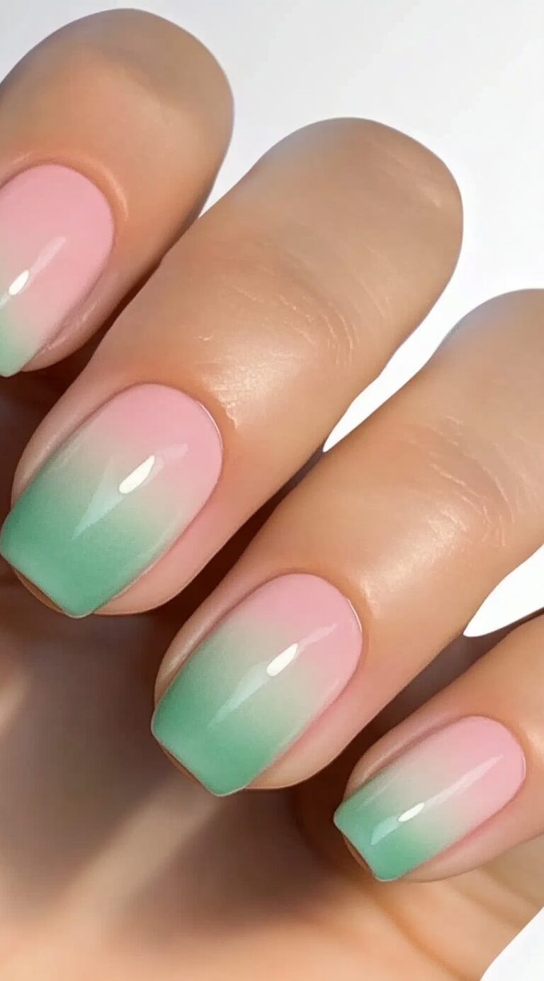 Short square-shaped nails with a soft pink and green ombre effect and a glossy top coat.