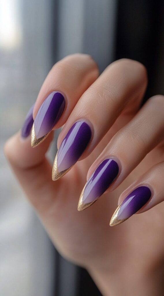 Pointed stiletto nails featuring a soft purple gradient with metallic gold foil accents on the tips.